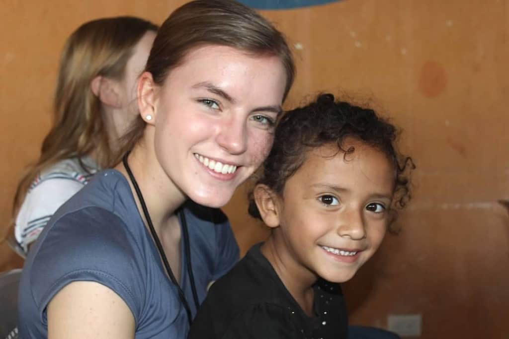 A woman and the child she sponsors through Compassion smile.