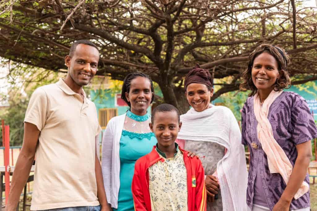 Abel stands with Mr. Abaya (project director), Shahitu (health worker), Astede (Abel’s mom) and Meseret (social worker).]