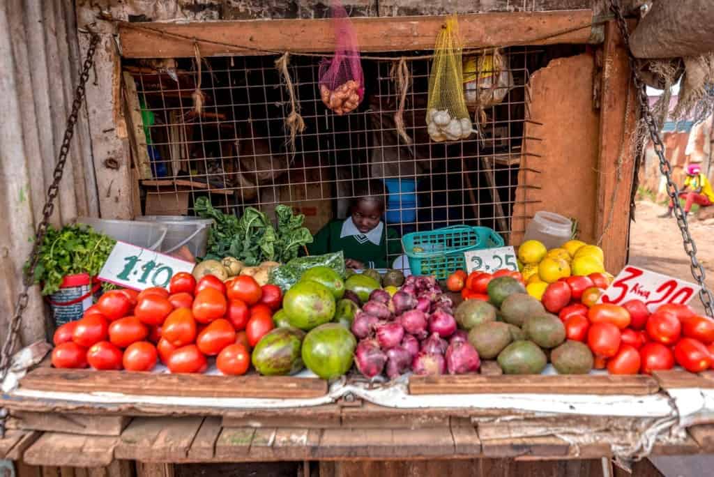 Tracy is pictured here sitting behind a display of fruits at her grandmother's shop.