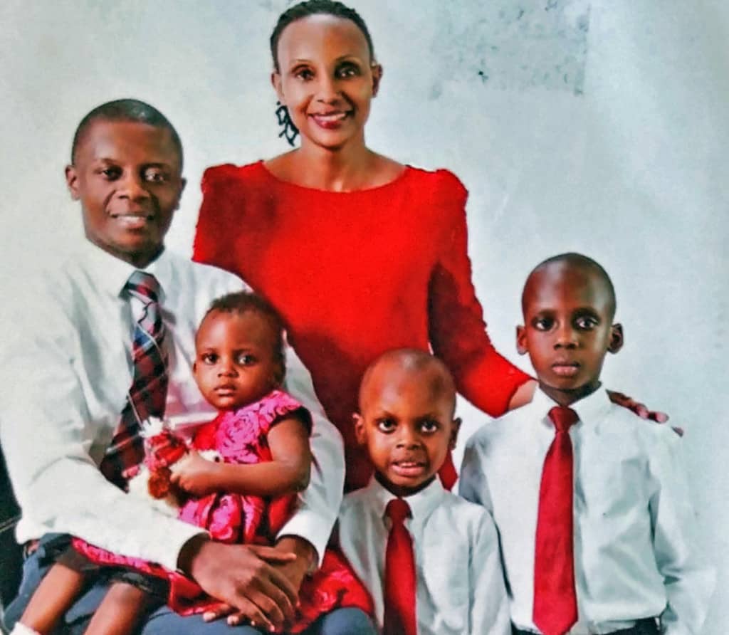 Norah and her family. Norah wears a red shirt, while her husband and two sons wear white shirts and red ties. Their young daughter wears a red dress.