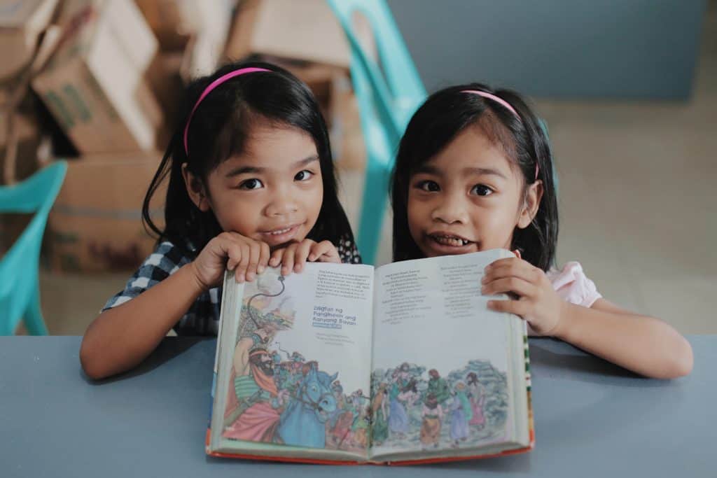 Two girls in the Philippines hold a children's Bible.