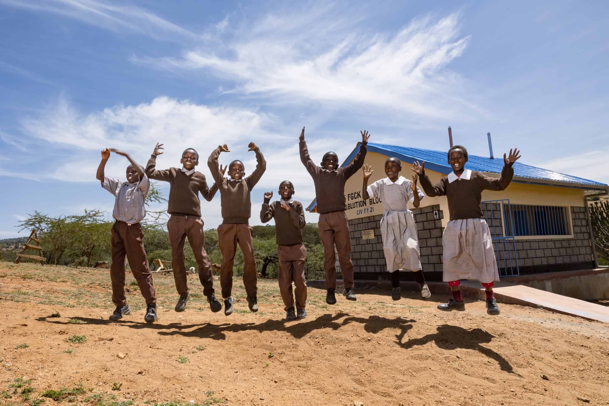 A group of children jump up in the air with joy. Compassion International